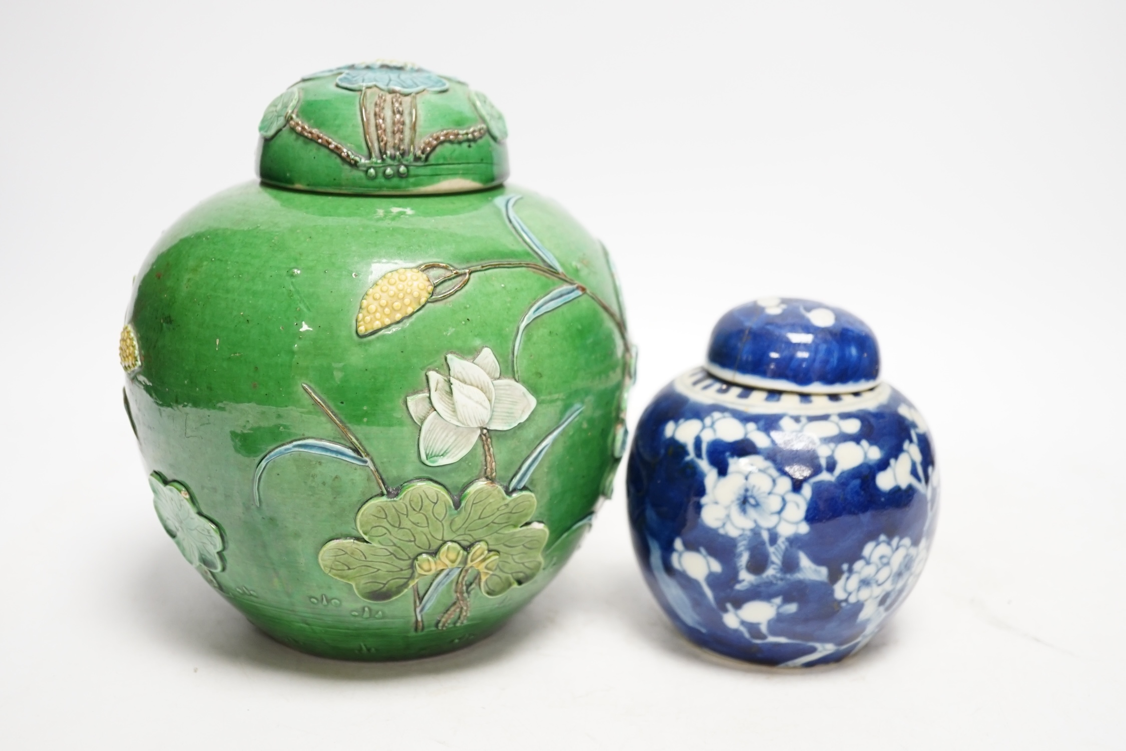 Two Chinese lidded ginger jars, one with applied decoration and the other with blue and white prunus decoration, tallest 18cm. Condition - fair, one lid restored